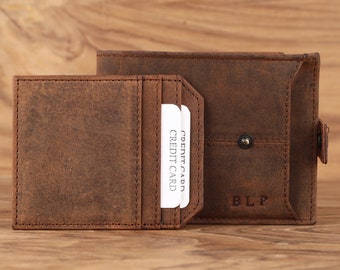 May include: A brown leather wallet with a flap closure and a card slot. The wallet has a small pocket on the front with the letters "BLP" embossed on it.