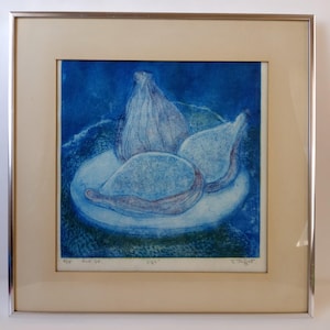 May include: A framed print featuring a still life of figs. The artwork depicts whole and sliced figs on a plate, rendered in shades of blue. The print is set against a blue background and framed in a silver metal frame.
