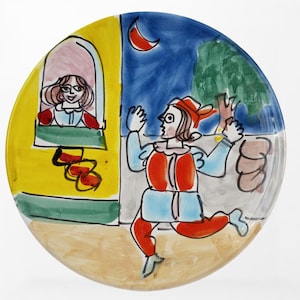 May include: A hand-painted ceramic plate featuring a whimsical scene. A figure in red and blue clothing gestures towards a window where another figure is visible. The background includes a night sky with a crescent moon and a tree. The plate is round.