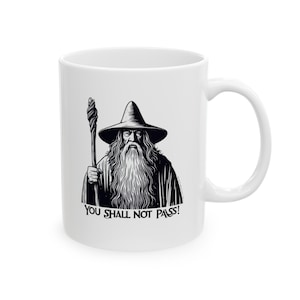 May include: White ceramic mug with a black and white illustration of Gandalf from The Lord of the Rings. The illustration shows Gandalf with his staff and a long white beard. The text "YOU SHALL NOT PASS!" is printed below the illustration.