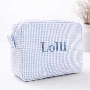 May include: A white ceramic mug with a black handle and the text "But First, Coffee" in a bold, black font. The mug sits on a white surface, showcasing its clean design.