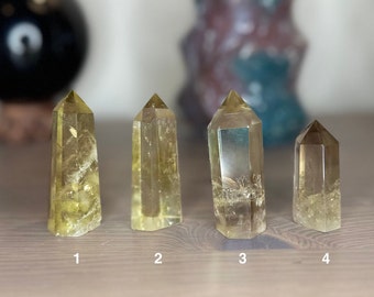 May include: Four clear quartz crystal points with a yellow hue. The crystals are arranged in a row from left to right, numbered 1 through 4.