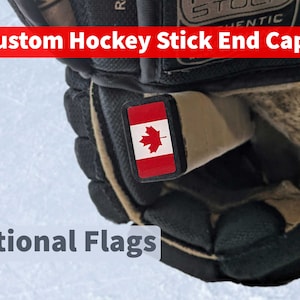 May include: A black hockey glove with a custom end cap featuring the Canadian flag. The end cap is a small rectangular sticker with the Canadian flag design. The text "Custom Hockey Stick End Cap" and "National Flags" are visible in the image.