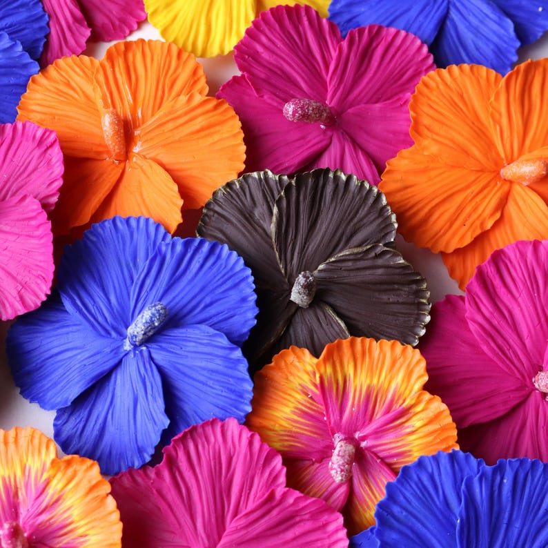 K&ouml;nnte beinhalten: Sortiment aus bunten Stoff-Hibiskusbl&uuml;ten in den Farben Pink, Orange, Blau, Gelb und Braun. Die Bl&uuml;ten sind aus Stoff gefertigt und haben eine geschichtete, gekr&auml;uselte Optik.