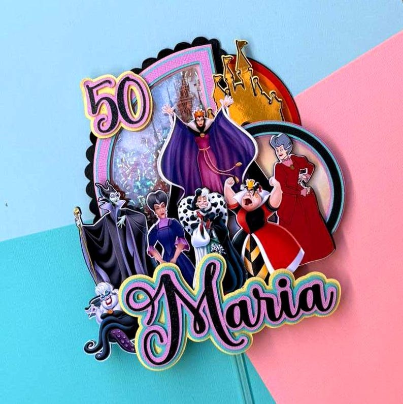 May include: A colorful cake topper featuring Disney villains, the number 50, and the name "Maria." The design includes images of a castle and various characters in vibrant colors. The background is a mix of pink and blue.