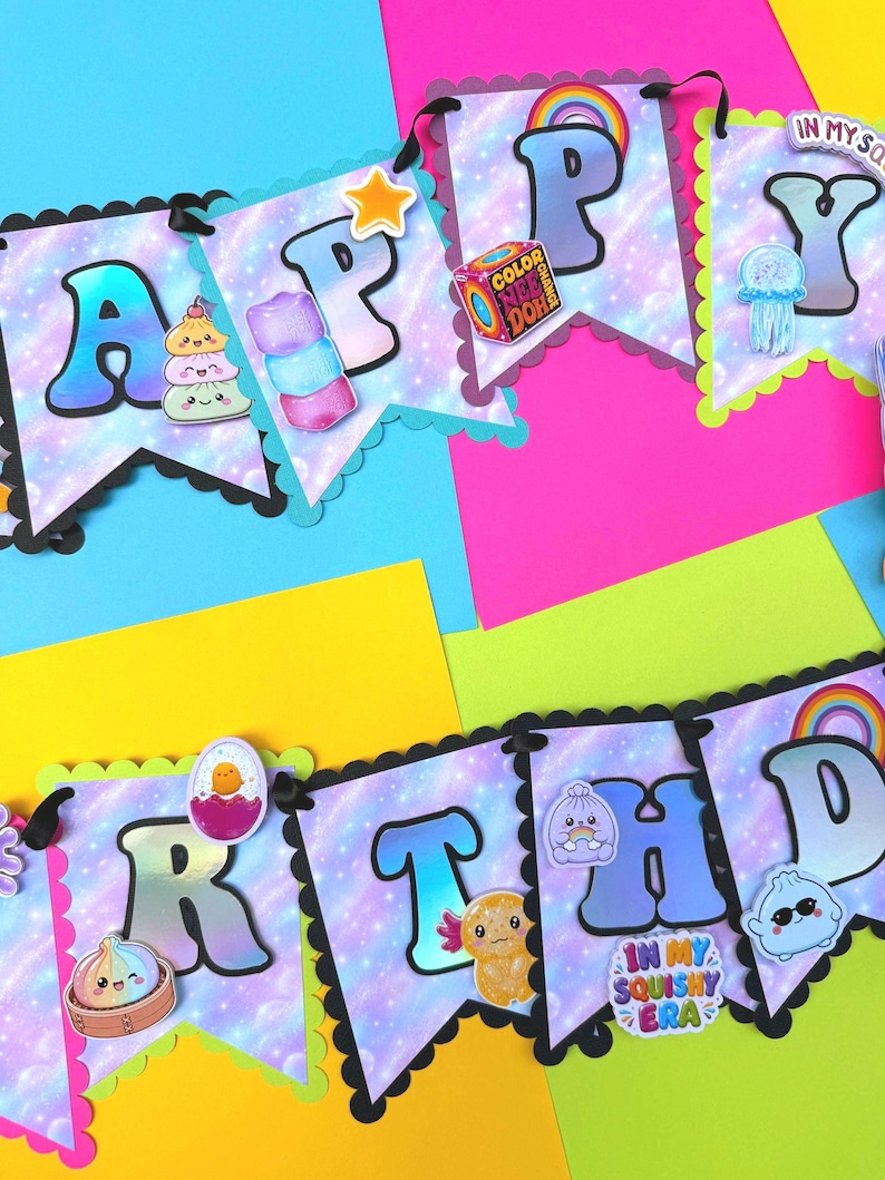 Puede incluir: Una guirnalda decorativa que deletrea HAPPY BIRTHDAY con banderines de estampado de galaxia morada, bordes festoneados y varios recortes tem&aacute;ticos de juguetes blandos, incluyendo un arco&iacute;ris, un cubo, una medusa y el texto IN MY SQUISHY ERA.