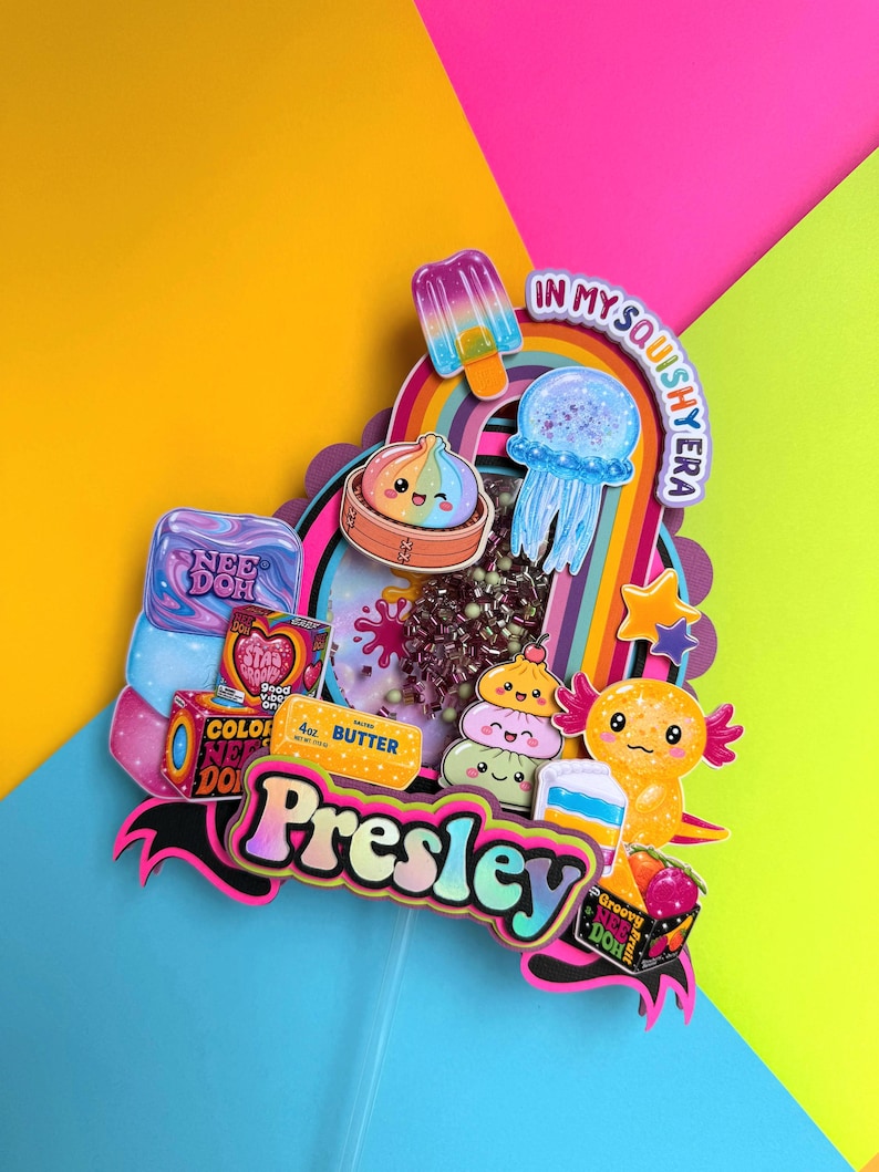 Puede incluir: Un adorno para pastel de varias capas con el nombre Presley en una fuente degradada, rodeado de recortes coloridos de una paleta, medusa, ajolote, una barra de mantequilla y varios juguetes, con el texto In My Squishy Era en la parte superior.