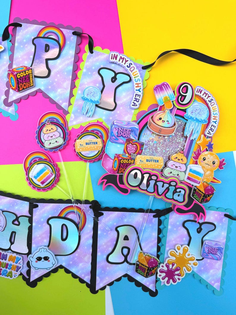 Puede incluir: Un conjunto de bander&iacute;n de cumplea&ntilde;os y adorno para pastel con fondo de galaxia y el texto "HAPPY" y "Olivia". Las decoraciones incluyen gr&aacute;ficos coloridos de juguetes, arco&iacute;ris, medusas y la marca "NEE DOH" sobre una cinta negra.