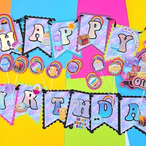 Puede incluir: Un conjunto de pancartas de Happy Birthday con banderines de patr&oacute;n gal&aacute;ctico en tonos pastel, bordes festoneados negros, detalles de arco&iacute;ris y gr&aacute;ficos de juguetes squishy. Incluye un adorno para pastel personalizado con el nombre Olivia y el n&uacute;mero 9.