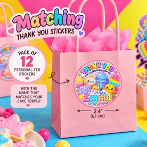 Puede incluir: Una bolsa de regalo de papel rosa claro con asas de papel trenzado rosa y papel de seda rosa en el interior. Una pegatina redonda en la bolsa presenta personajes de dibujos animados coloridos, el texto "THANK YOU FOR CELEBRATING WITH ME!" y "Emma", con un ancho de 6,1 cm.