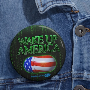 May include: A black button with a green "WAKE UP AMERICA" message and a red, white, and blue pill-shaped American flag graphic. The background is a green matrix of code. The text "Brought to you by Patriots" is at the bottom of the button.