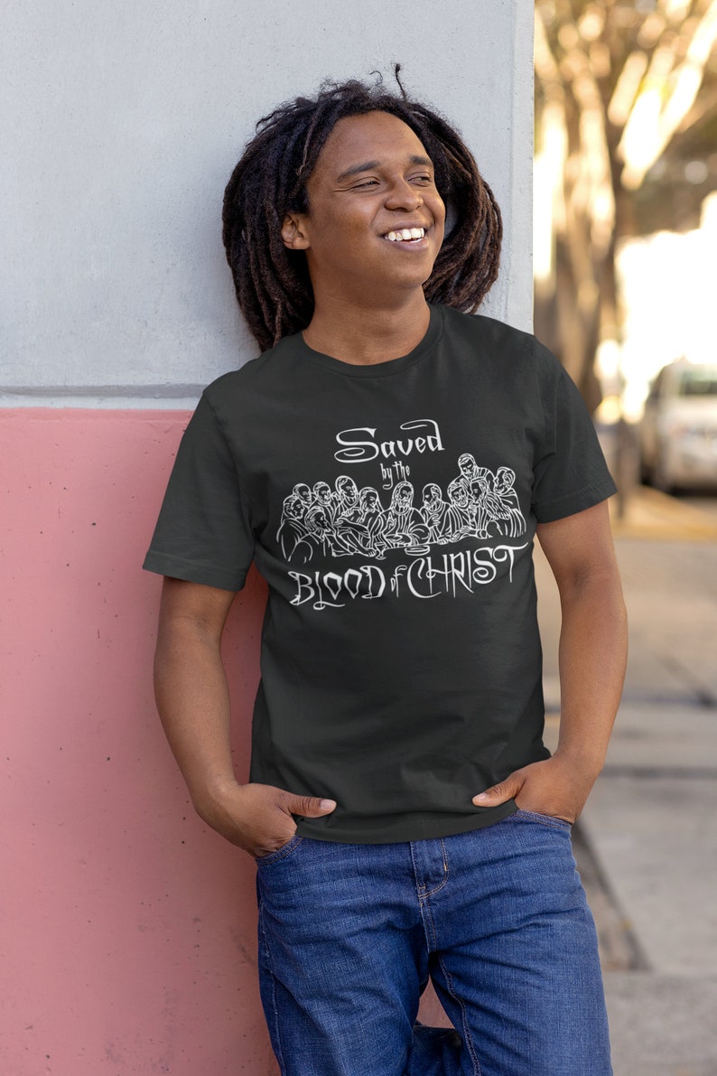 May include: A black t-shirt featuring a white graphic of the Last Supper and the text "Saved by the Blood of Christ".