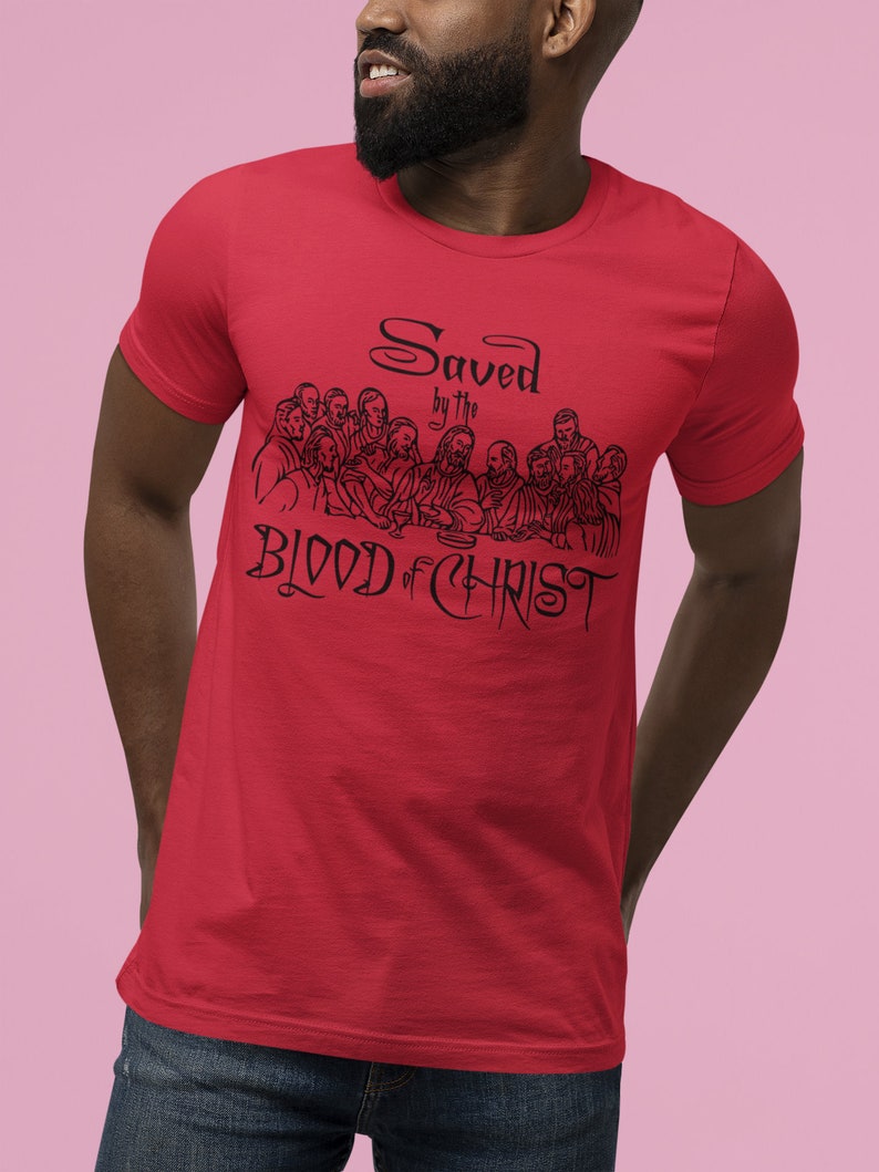 May include: Red t-shirt featuring a black graphic of the Last Supper and the text "Saved by the Blood of Christ".