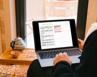 May include: A person is working on a laptop computer with a spreadsheet open on the screen. The spreadsheet is titled "Comprehensive WEEKLY Budget".