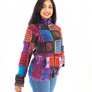 May include: A colourful patchwork jacket with a zip fastening and multiple pockets. The jacket is made from different fabrics and has a distressed look. The model is wearing blue jeans.