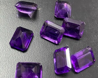 Könnte beinhalten: Sieben rechteckig geschliffene Amethyst-Edelsteine in tiefem Lila. Die geschliffenen Edelsteine haben eine polierte Oberfläche und sind auf dunklem Untergrund angeordnet. Die Edelsteine sind etwa 1-2 cm lang.