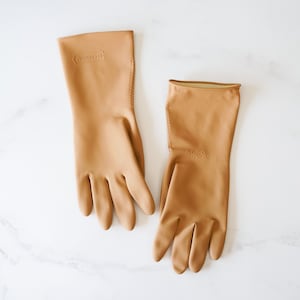 May include: A pair of brown rubber gloves with the word "Goodwear" embossed on the cuff.