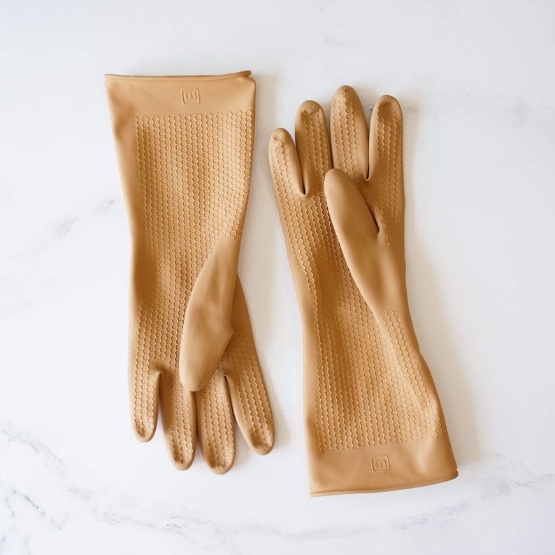 May include: A pair of tan rubber dishwashing gloves with a honeycomb texture. The gloves have the letter "W" printed on the back of each glove.