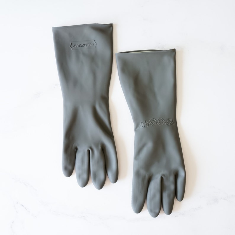 May include: A pair of gray rubber gloves with textured fingertips. The gloves have a raised logo that says "Glamware" on one glove and a row of raised geometric shapes on the other.