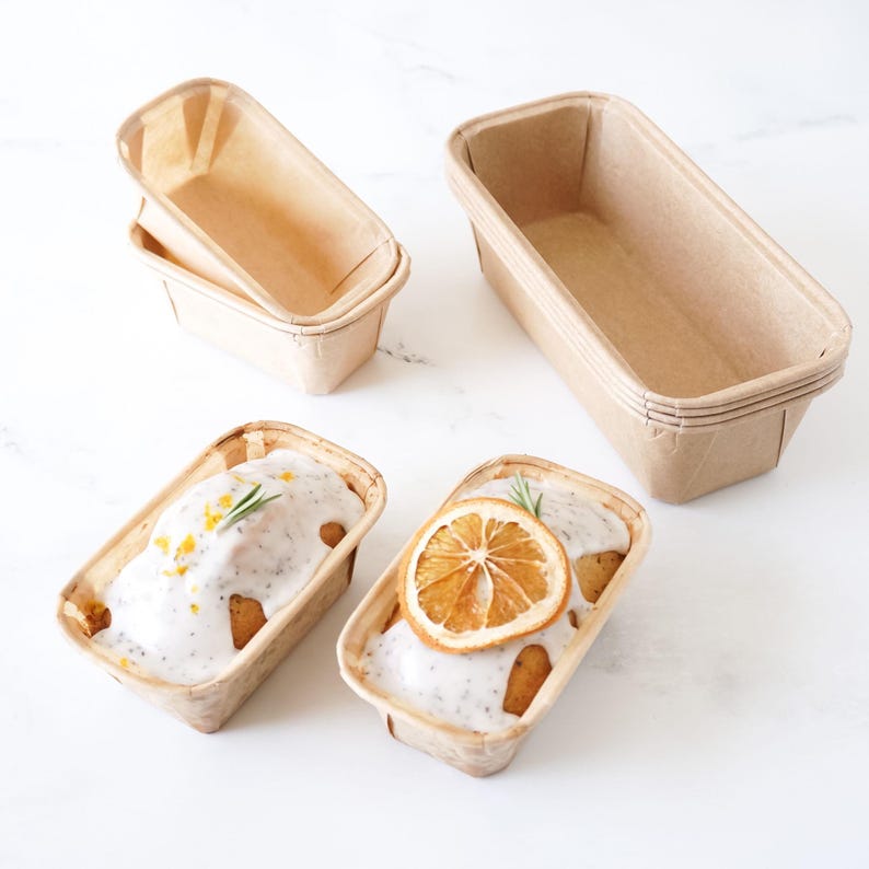 Set of mini loaf pans with baked goods on a white background