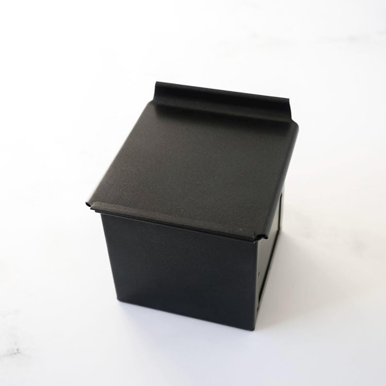 Black square bread loaf pan on a white background