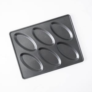 May include: A rectangular dark gray metal baking pan featuring six individual oval-shaped indentations arranged in two rows of three. The surface has a smooth, non-stick finish with a raised outer rim and a small embossed logo in the top right corner.