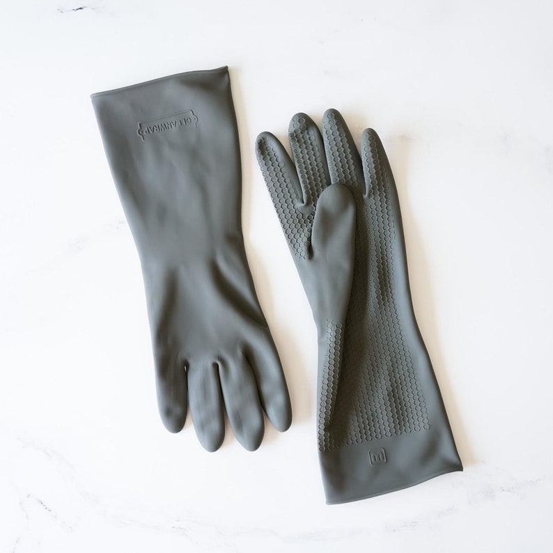May include: A pair of gray rubber gloves. One glove has a textured surface and the other is smooth. The gloves have the text "Good Grips" printed on them.