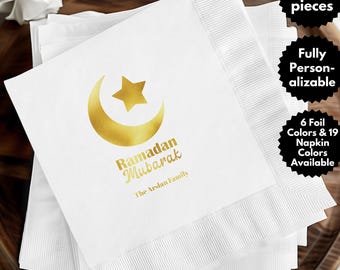 May include: A set of 50 white paper napkins with a gold foil crescent moon and star design. The text "Ramadan Mubarak" and "The Arslan Family" is printed in gold foil.