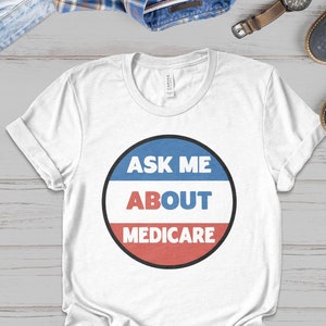 May include: White t-shirt with a red, white, and blue circle that says "Ask Me About Medicare".