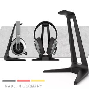Könnte beinhalten: Schwarze Kopfhörerständer mit Kopfhörern. Die Ständer haben ein schlankes, modernes Design. Die Kopfhörer sind silber und schwarz. Der Text "MADE IN GERMANY" befindet sich am unteren Rand des Bildes.