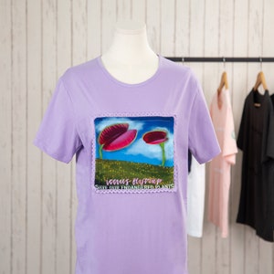 May include: Purple t-shirt with a graphic of a Venus flytrap plant with the text "Venus Flytrap Save Our Endangered Plants".