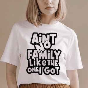 May include: White t-shirt with black text that reads "Ain't no family like the one I got".