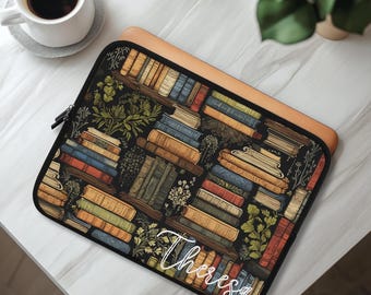 Puede incluir: Una funda rectangular para portátil con fondo negro y un patrón repetitivo de libros apilados e ilustraciones botánicas verdes. El nombre Theresa está escrito en letra cursiva blanca en la esquina inferior derecha de la funda.