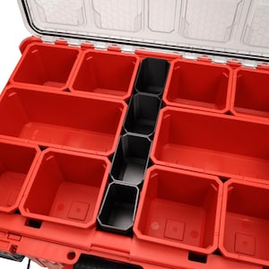 Puede incluir: Una caja de almacenamiento de plástico roja con tapa transparente y múltiples compartimentos. Los divisores negros crean compartimentos de varios tamaños. Ideal para organizar herramientas o objetos pequeños.