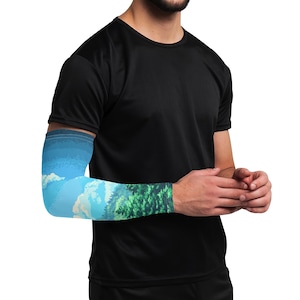 May include: A blue and green arm sleeve with a landscape design. The sleeve features a blue sky with white clouds and a green forest in the foreground.