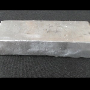May include: A silver-coloured metal bar, likely aluminium, with a slightly textured surface. The bar is rectangular and has a smooth, polished finish.