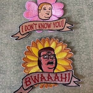 May include: Two embroidered patches featuring a cartoon character with the text "I don't know you!" and "Bwaah!"