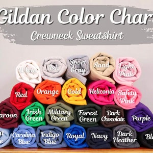 May include: A color chart for Gildan crewneck sweatshirts. The chart shows 18 different colors, including white, ash, sport gray, sand, light pink, red, orange, gold, heliconia, safety pink, maroon, Irish green, military green, forest green, dark chocolate, purple, light blue, Carolina blue, indigo blue, royal blue, navy, dark heather, and black.