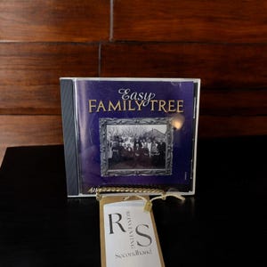 May include: A CD case with the title "Easy Family Tree" on a purple background. The case has a photo of a family in a frame. A tag with the letters "R" and "S" and the word "Secondhand" hangs in front of the case.
