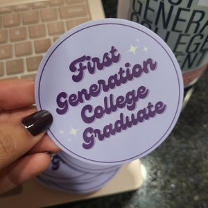 Könnte beinhalten: Runder Aufkleber in Lila und Weiß mit dem Text "First Generation College Graduate" in einer Retro-Schrift.