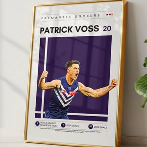 May include: A framed vertical poster featuring a graphic of Australian rules football player Patrick Voss in a purple and white Fremantle Dockers jersey. The text includes his name, the number 20, and statistics for 2024 and 2025 goals scored.