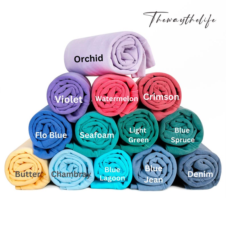 May include: A stack of rolled fabric swatches in various colours, including orchid, violet, watermelon, crimson, flo blue, seafoam, light green, blue spruce, butter, chambray, blue lagoon, blue jean, and denim.