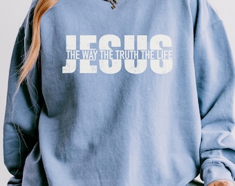 May include: A light blue sweatshirt with the text "JESUS THE WAY THE TRUTH THE LIFE" printed in white.