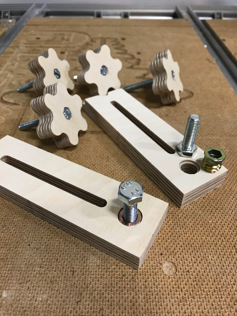 May include: Two wooden blocks with a slot cut out of the center. Each block has a metal bolt and nut attached. There are five wooden knobs with a star-shaped design.