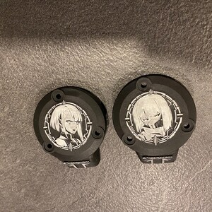 May include: Two circular black metal covers featuring white laser-etched anime-style character portraits within a circular frame. Each cover has two mounting holes and a small rectangular tab at the bottom with the text CYBERPUNK printed in white.