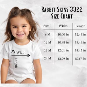 May include: A child in a white t-shirt, with a Rabbit Skins 3322 size chart. The chart displays width and length measurements in inches for sizes 6M, 12M, 18M, and 24M. Measurements are in inches.