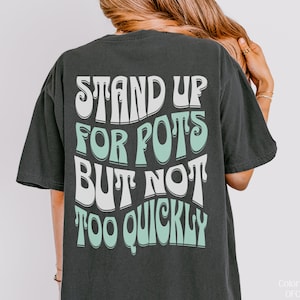 Pode incluir: Uma camiseta preta com uma estampa gráfica branca e verde que diz "Stand Up For Pots But Not Too Quickly".