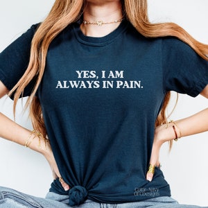 K&ouml;nnte beinhalten: Ein marineblaues T-Shirt mit dem Aufdruck "YES, I AM ALWAYS IN PAIN." in wei&szlig;.