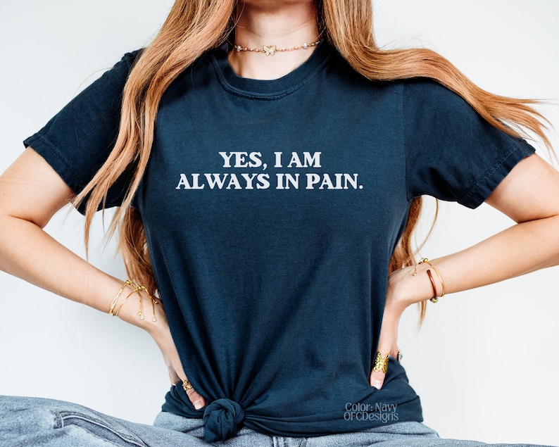 K&ouml;nnte beinhalten: Ein marineblaues T-Shirt mit dem Aufdruck "YES, I AM ALWAYS IN PAIN." in wei&szlig;.