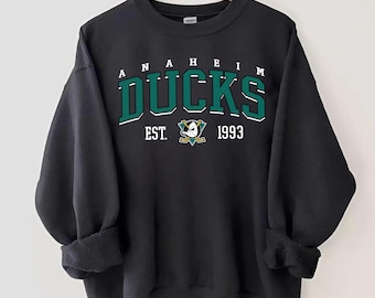 May include: Black sweatshirt with a green and white Anaheim Ducks logo and the text "ANAHEIM DUCKS EST. 1993".